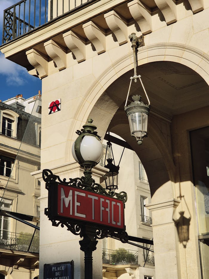 services-03 Elegant Paris Metro sign and classic architecture in bright daylight.