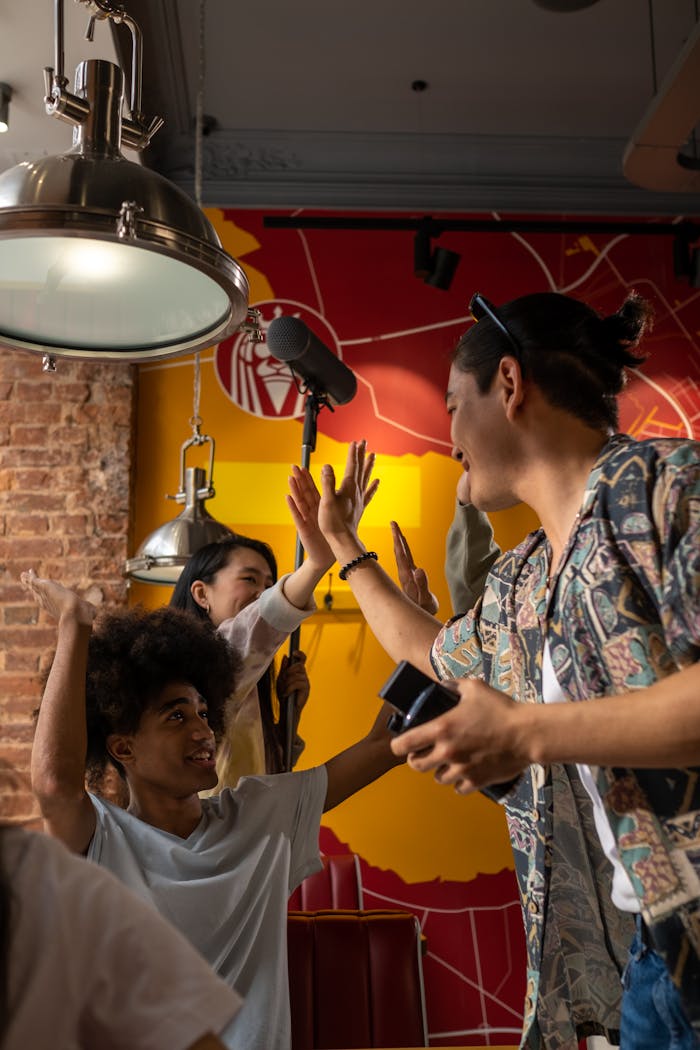 A lively group of diverse friends exchanging high fives in a cozy café setting.